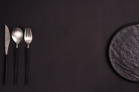 Creative tableware set from ceramic plate served fork, spoon and knife on the same color background,...