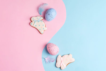 Two handmade Easter painted eggs and cookies on a duo-tone pastel colored