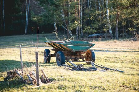 Old green cart and horse cart on a field in a villageの写真素材
