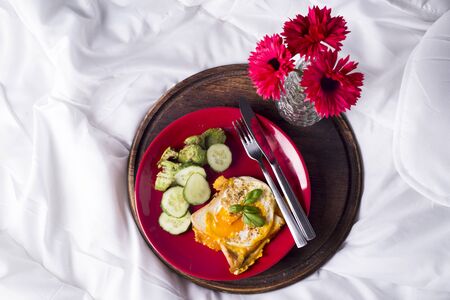 Fried eggs with toasts and tea in bedの写真素材