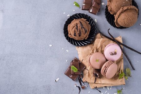 Chocolate macaroons with ice cream mint leaves and chunks of chocolate with space under the text flat layの写真素材