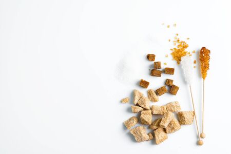 Various types of sugar brown cane, white granulated sugar, refined and crystal sugar stick on a white background, copy space. Top view.の写真素材