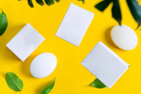 Floating handmade organic soap bar and paper boxes for packaging natural products and things above yellow background, copy space. Mock-up for your design and creativity.の写真素材