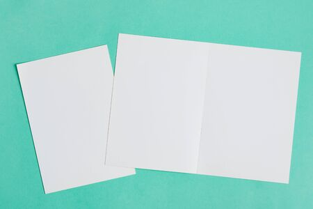 Empty blank mockup sheet of white paper for writing letters, messages or text on a pastel turquoise background, copy space. Top view.の写真素材