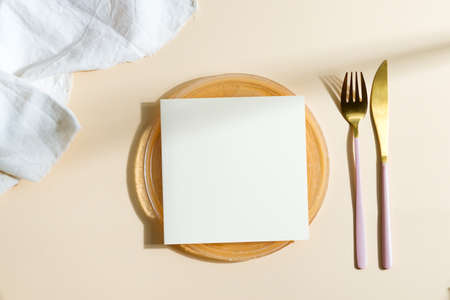 Dinner wooden board served fork, knife with paper card.の写真素材