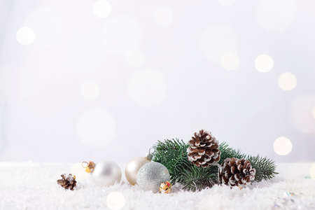 Christmas bauble on a fir branch with pine cone and glitter backgroundの写真素材