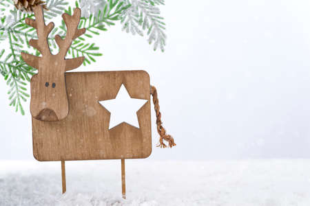 Wooden Christmas deer with fir tree on snowの写真素材