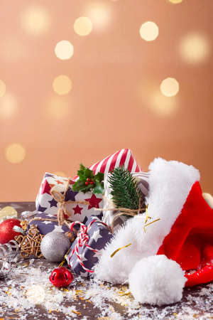 Christmas holidays composition with Santa Claus red hat and gift boxes on wooden backgroundの写真素材
