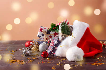 Christmas holidays composition with Santa Claus red hat and gift boxes on wooden backgroundの写真素材
