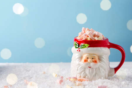 Christmas santa cup of hot chocolate with marshmallow on blueの写真素材