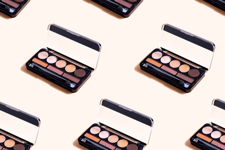 Eyeshadow palette on beige background, eye shadows cosmetics product . Seamless pattern.の写真素材