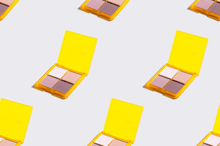 Eyeshadow yellow palette on grey background, eye shadows cosmetics product . Seamless pattern.