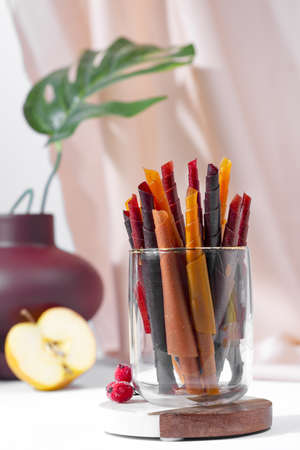 Colorful fruit leather rolls on a plate on light backgroundの写真素材