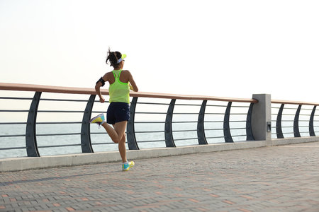 young fitness woman runner running at seasideの写真素材
