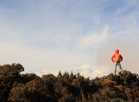young woman backpacker hiking to beautiful mountain peakの写真素材