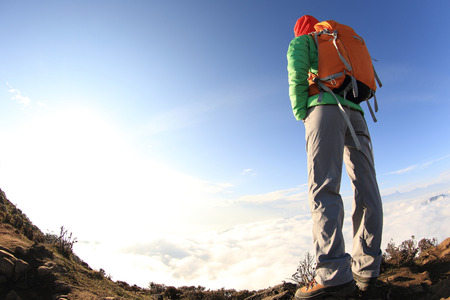 young woman backpacker hiking to beautiful mountain peakの写真素材