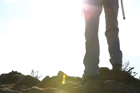 hiker legs on sunset mountain peak enjoy the viewの写真素材