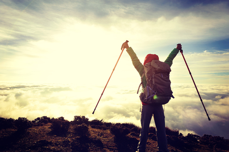 success young woman backpacker at sunrise mountain peakの写真素材