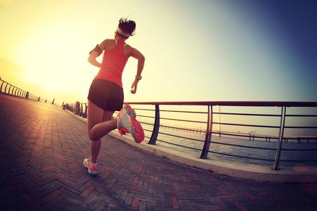 young fitness woman runner running at seasideの写真素材