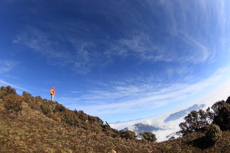 young woman backpacker hiking to beautiful mountain peakの写真素材