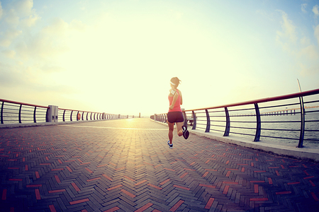 young fitness woman runner running at seasideの写真素材
