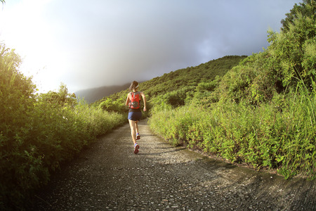 young fitness woman runner running on mountain trailの写真素材
