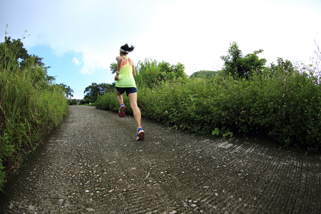 young fitness woman runner running on mountain trailの写真素材
