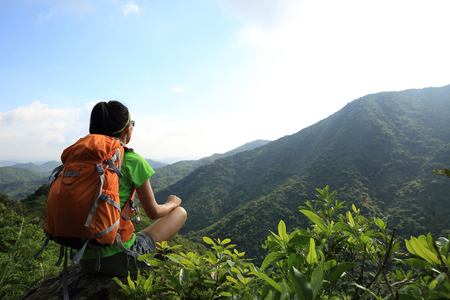 woman backpacker enjoy the view at mountain peak cliffの写真素材