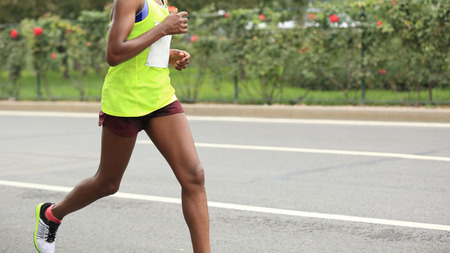 Marathon runner running on city roadの写真素材