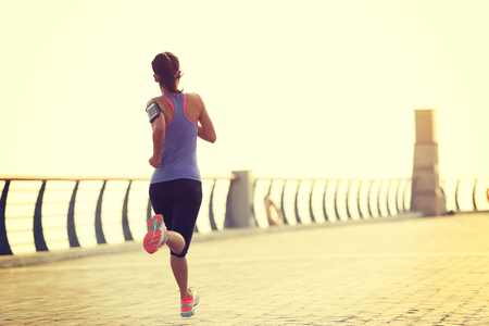 young woman runner athlete running at seasideの写真素材