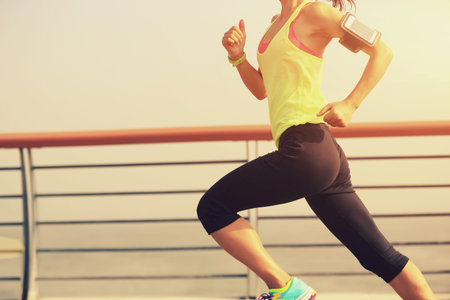 young fitness woman runner running at seaside