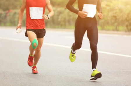 Marathon runners running on city roadの写真素材