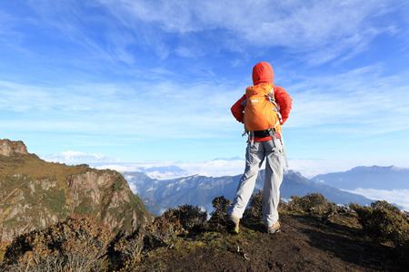 young woman hiker hiking on mountain peakの写真素材