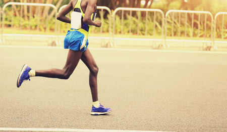 Marathon runner running on city roadの写真素材