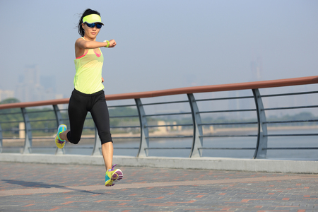 young fitness woman runner running at seasideの写真素材
