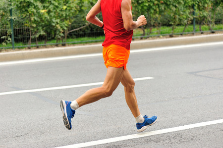 Marathon runner running on city roadの写真素材