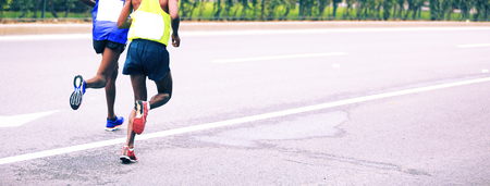 Marathon runners running on city roadの写真素材