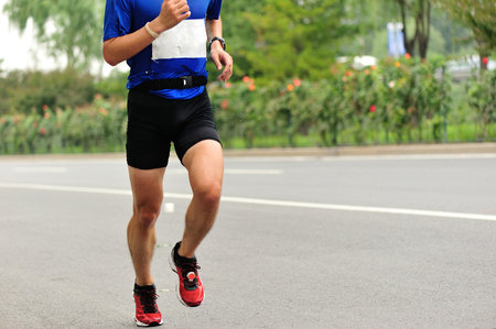 Marathon runner running on city roadの写真素材