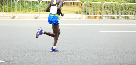 Marathon runner running on city roadの写真素材