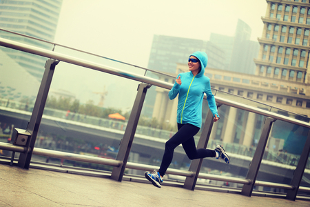 young fitness woman runner running at shanghai cityの写真素材