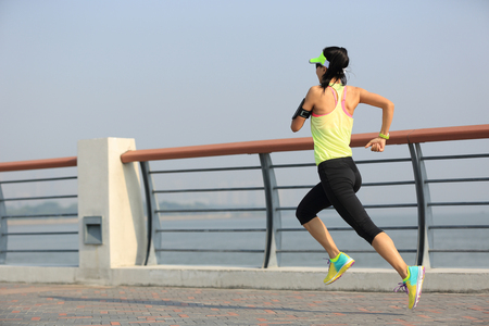 young fitness woman runner running at seasideの写真素材