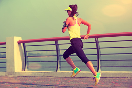 young fitness woman runner running at seasideの写真素材