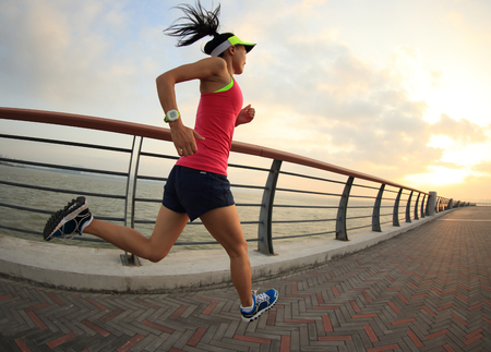 Runner athlete running at seaside. woman fitness silhouette sunrise jogging workout wellness concept.の写真素材