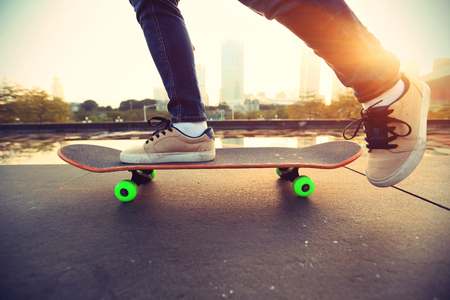skateboarder skateboarding at sunrise cityの写真素材