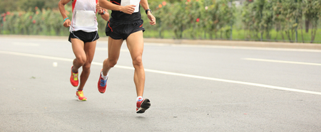 Marathon runners running on city roadの写真素材