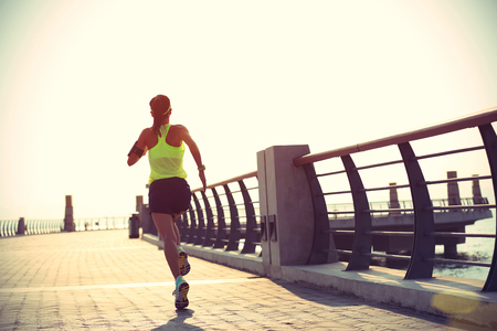 young fitness woman runner running at seasideの写真素材
