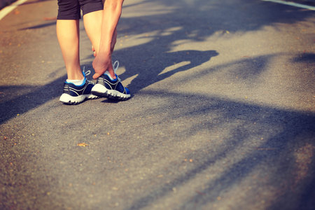 woman runner hold her sports injured leg woman runner hold her sports injured ankle
