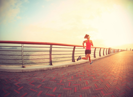 young fitness woman runner running at seasideの写真素材