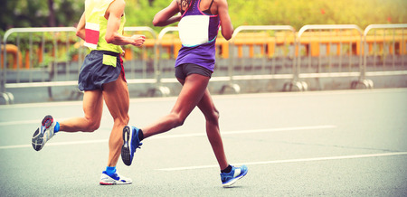 Marathon runners running on city roadの写真素材