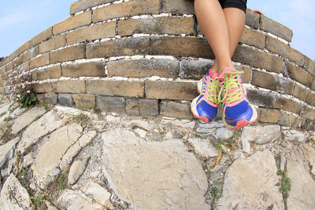 ftiness woman runner legs sit on great wallの写真素材
